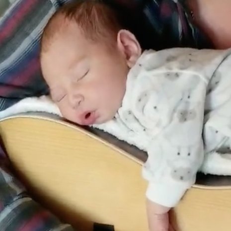 video vader sust baby in slaap met gitaar